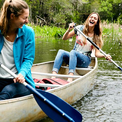 two uwf students in a canoe on thompson bayou on the pensacola campus